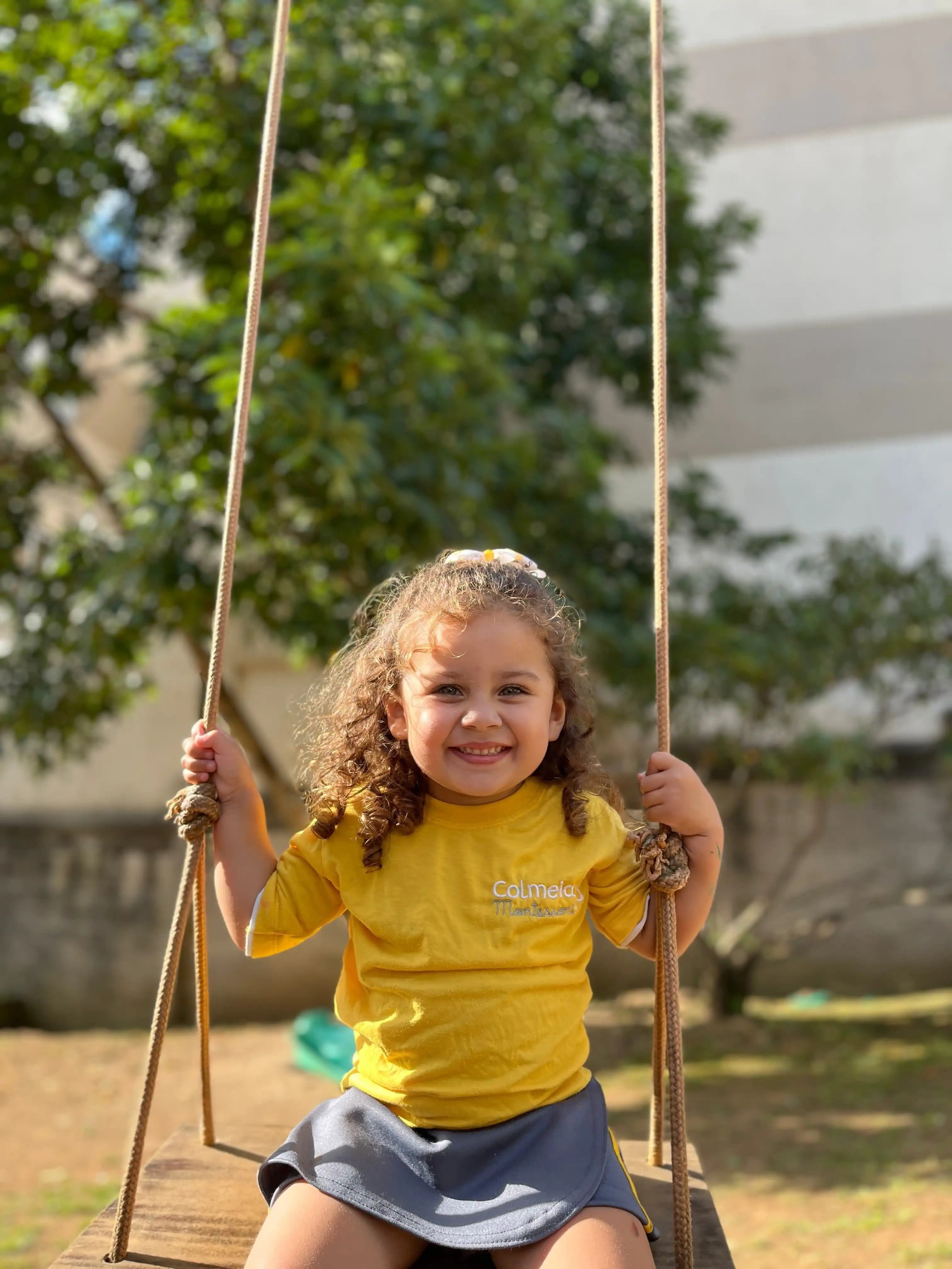 criança brincando de balanço na colmeia montessori